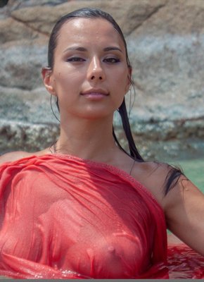 Голая девушка эротично позирует в море