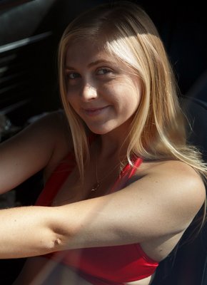 Молодая светловолосая девка позирует у машины